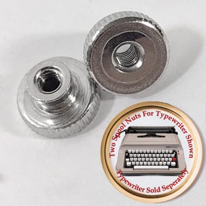 May include: Two silver-colored spool nuts for a typewriter. The nuts have a knurled edge for easy grip and a threaded hole in the center. A circular graphic shows a typewriter and text that reads "Two Spool Nuts For Typewriter Shown. Typewriter Sold Separately."