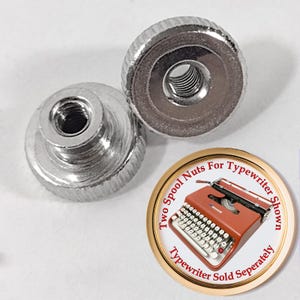May include: Two silver spool nuts for a typewriter. The nuts are round with a ridged edge and a threaded hole in the center. A circular graphic shows a red typewriter and text that reads "Two Spool Nuts For Typewriter Shown, Typewriter Sold Separately."
