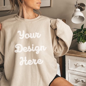 May include: An oversized beige sweatshirt with the text "Your Design Here" printed in white.