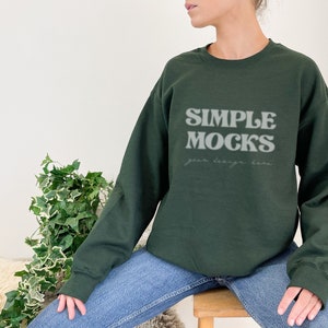 May include: A dark green sweatshirt with the text "SIMPLE MOCKS your design here" in white.