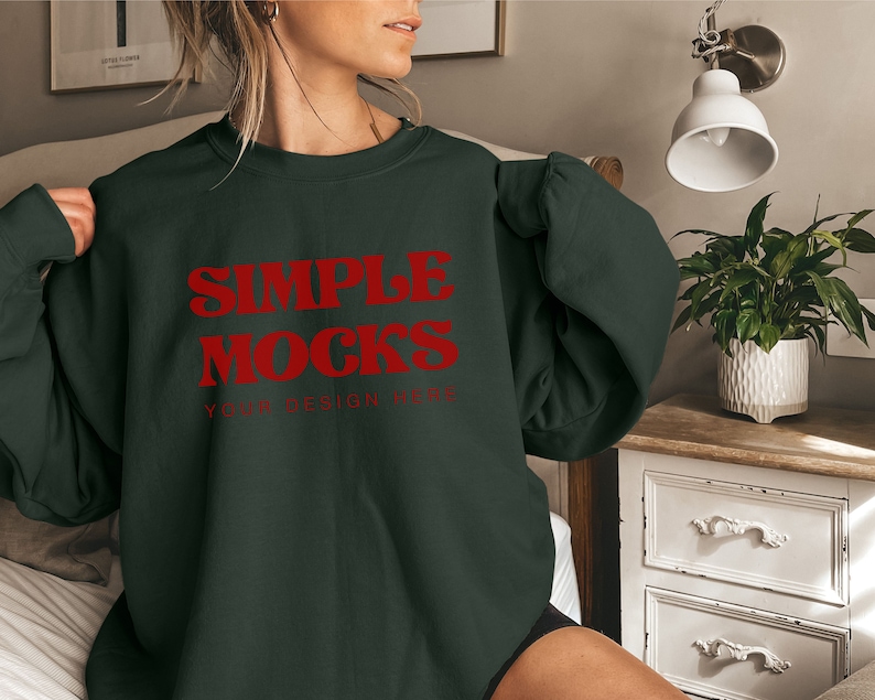 May include: A dark green sweatshirt with the text "SIMPLE MOCKS YOUR DESIGN HERE" in red lettering.