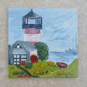 May include: A painting depicting a red and white lighthouse with a grey roof and a small house in front of it. The lighthouse is situated on a grassy hill with a blue body of water in the background. A small red boat can be seen in the water.