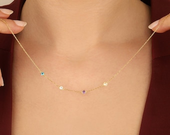 May include: A gold chain necklace with five small gemstones. The gemstones are blue, white, purple, and yellow.