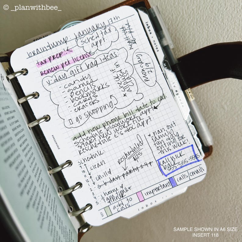 Op de afbeelding: Een planner-inzet met handgeschreven notities en een pen. De notities bevatten een takenlijst, een schema en herinneringen. De tekst bevat "braindump", "V-day gift bag ideas" en "Call Nick". De inzet wordt getoond in A6-formaat.