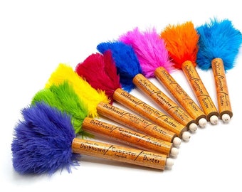 Puede incluir: Un conjunto de ocho plumeros de plumas de colores con mangos de madera. Cada plumero tiene el texto "Dashboard/Computer/Duster" impreso en el mango.