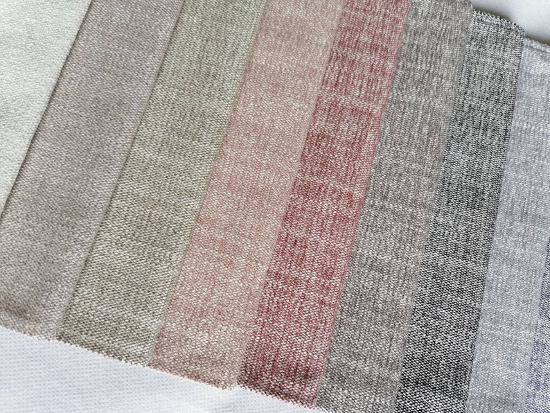 May include: A close-up of a variety of fabric swatches in different shades of beige, pink, and gray. The swatches are arranged in a row, with the lightest shade at the top and the darkest shade at the bottom.