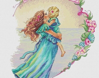 May include: A mother and daughter embrace in a heart-shaped floral frame. The mother is wearing a flowing blue dress and the daughter is wearing a blue dress. The background is a light blue ocean.