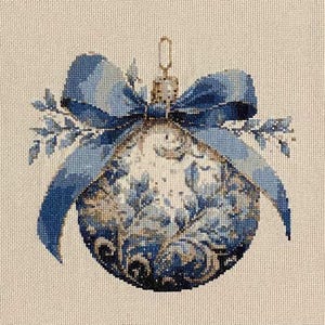 May include: A blue and white Christmas ornament with a bow and floral design. The ornament has a gold-colored metal loop for hanging. The bow and floral design are in shades of blue.