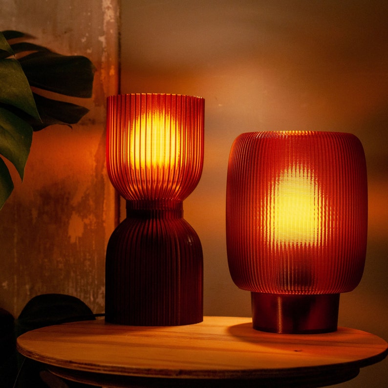 DIABOLO lamp in a cozy reading nook providing inviting warm ambient lighting. Handcrafted from recycled plastic for a sustainable touch. Fits perfectly in modern, minimalist, or boho interiors to create an inviting atmosphere.