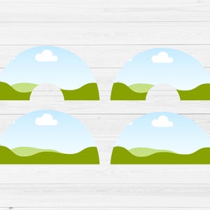 May include: Four printable cupcake toppers featuring a green grassy hill with a blue sky and white clouds. The toppers are shaped like half circles.