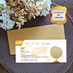 Puede incluir: Un billete de viaje dorado con el texto "BILLET DE VOYAGE" y un diseño de mapa del mundo. El billete incluye una fecha de salida del 5 de marzo de 2026 y un mensaje personalizado. Un sobre dorado y un arreglo floral están en el fondo.