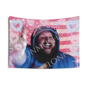 May include: A tapestry featuring a smiling person wearing a blue hoodie and headphones, giving a thumbs-up. The background has a pink and white American flag design with hearts and stars. The text "ELONMUSH" is visible.
