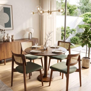 May include: A round wooden dining table with four chairs featuring green fabric seats and woven cane backrests. The table is set with white plates and clear glasses. A brass chandelier with six glass globes hangs above the table.