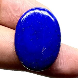 Peut inclure: Une pierre précieuse ovale de couleur bleu foncé, probablement du lapis-lazuli, avec une surface lisse et polie.
