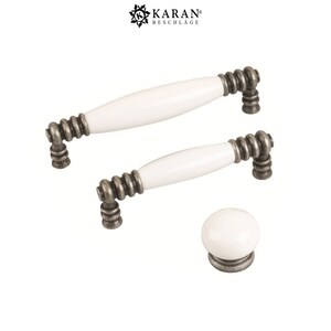 May include: Three white ceramic cabinet knobs with antique silver finish. The knobs are in different sizes, with two being long and one being round.
