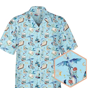May include: A light blue short-sleeved button-up shirt with a repeating pattern of dragons, books, and flowers. The shirt has a white button-up collar and a pocket on the left side.