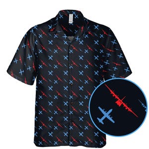 May include: Black short-sleeved shirt with a pattern of red and blue airplane motifs. The shirt features a button-down design and a classic collar. The design is repeated across the fabric. A close-up shows the airplane design.