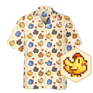 Könnte beinhalten: Ein gelbes, kurzärmeliges Hemd mit Knöpfen und einem pixelartigen Muster aus Hühnern, Herzen und Sternen. Das Hemd hat einen Kragen und eine lockere Passform.