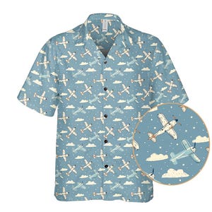 Peut inclure: Chemise bleu clair à manches courtes avec un motif d'avions blancs, de nuages et d'étoiles. La chemise a un col classique et une coupe décontractée. Le motif d'avion ajoute une touche ludique, idéale pour un usage décontracté.