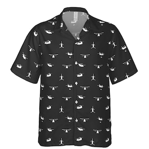 Puede incluir: Camisa negra de manga corta con un estampado de helic&oacute;pteros blancos. La camisa tiene un cuello cl&aacute;sico y un corte relajado. El dise&ntilde;o de helic&oacute;ptero se repite en toda la camisa.