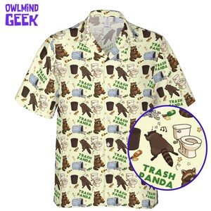 Pode incluir: Uma camisa de manga curta com bot&otilde;es em cor creme claro com uma estampa de guaxinins, vasos sanit&aacute;rios, latas de lixo e garrafas. O texto "TRASH PANDA" est&aacute; impresso em verde por todo o padr&atilde;o. A camisa possui gola e bot&otilde;es frontais.