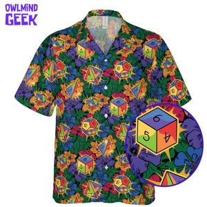 May include: Short-sleeved shirt with a button-down collar, featuring a colourful pattern of dice and flowers on a dark green background. The shirt has a close-up of a die. The text "OWLMINND GEEK" is in the upper left corner.
