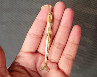 Op de afbeelding: Een gouden vis-hangerketting. De hanger is een realistische afbeelding van een vis met een gedetailleerde staart en lichaam.