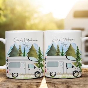May include: Two white ceramic mugs with personalised text and images. The mugs feature a watercolour design of a motorhome in a forest setting. The text on the mugs reads "Dave's Motorhome Mug" and "Julie's Motorhome Mug".