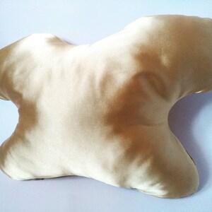 以下が含まれることがあります： 睡眠のために設計されたユニークな形のゴールドサテン枕。枕は柔らかく快適です。