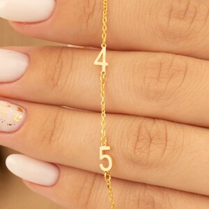 Hand gently holds a Rose Gold Plated Number Necklace, emphasizing its personal and delicate feel. Perfect for special cherished moments.