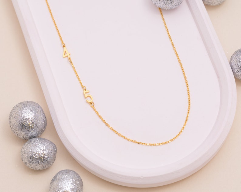 Mannequin displays varied chain lengths for the Personalized Number Necklace, helping customers visualize drops and choose their ideal custom fit.