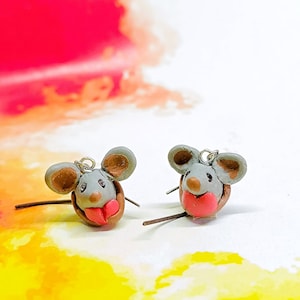 May include: A pair of gray mouse-shaped earrings with red hearts. The earrings are made of polymer clay and have silver hooks.