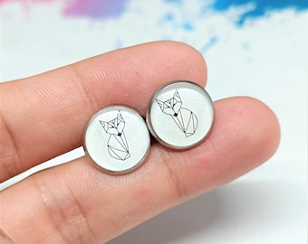 Könnte beinhalten: Ein Paar weiße Ohrstecker mit einem geometrischen Fuchs-Design. Der Fuchs ist in Schwarz umrandet und hat einen weißen Hintergrund.