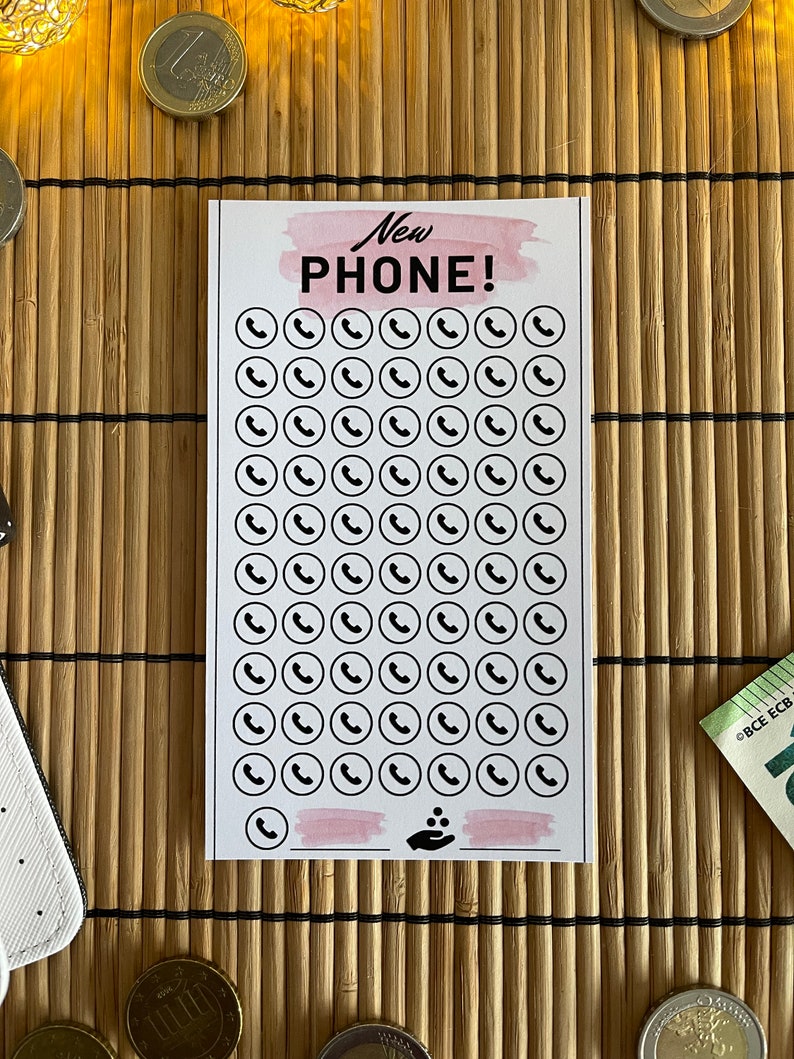 May include: A printable checklist with the text "New Phone!" at the top. The checklist has 70 phone icons in a grid pattern. There is a pink watercolor background behind the text and a pink watercolor line at the bottom of the checklist.
