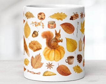 May include: A white ceramic mug featuring a watercolour pattern of autumn elements including a squirrel sitting on a pumpkin, various orange and yellow leaves, acorns, cinnamon sticks, a cookie, a slice of pie, a candle, and a small brown mug.