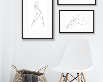 May include: Three black framed prints of line drawings of a person in different poses. The prints are hanging on a white wall above a white chair with wooden legs.