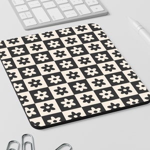 May include: Black and white checkered mouse pad with a repeating pattern of stylized flowers.