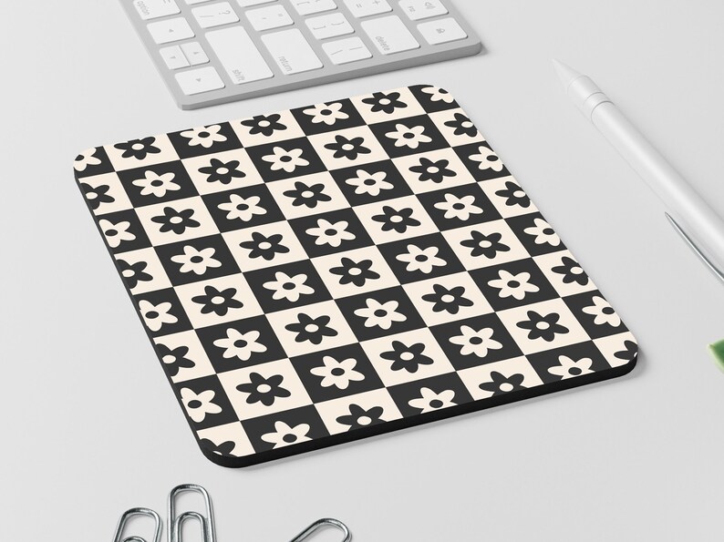May include: Black and white checkered mouse pad with a repeating pattern of stylized flowers.