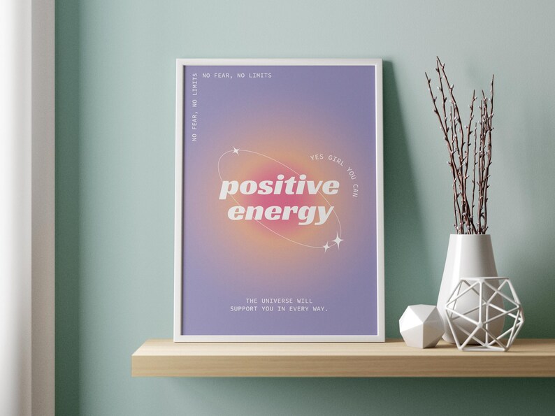 May include: A white framed print with a purple background and a pink and orange gradient circle with stars. The text on the print reads "YES GIRL YOU CAN positive energy THE UNIVERSE WILL SUPPORT YOU IN EVERY WAY."