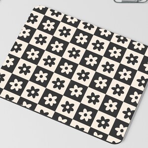 May include: Black and white checkered mouse pad with a repeating pattern of stylized black flowers.