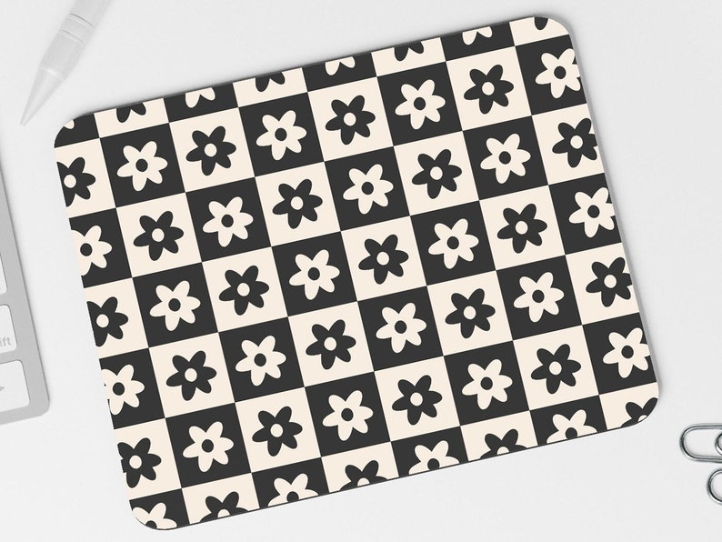 May include: Black and white mouse pad with a repeating pattern of stylized flowers. The flowers are arranged in a checkerboard pattern.