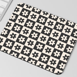 May include: Black and white checkered mouse pad with a repeating pattern of stylized flowers.