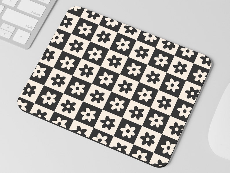 May include: Black and white checkered mouse pad with a repeating pattern of stylized flowers.
