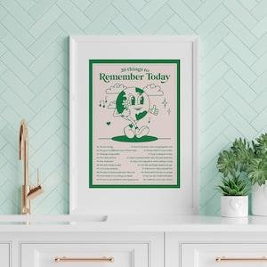 May include: A framed poster with a green cartoon character on a pink background. The poster says "20 things to remember today" and lists 20 affirmations.