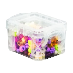 May include: A clear plastic storage container with a hinged lid. The container is filled with colorful beads in shades of purple, pink, yellow, and orange.