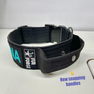 May include: Black dog collar with a turquoise embroidered name and the words "Fur Forge". The collar has a black buckle and a handle with a snap closure.