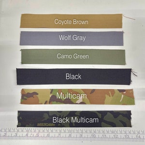 May include: A selection of fabric swatches in various colors, including Coyote Brown, Wolf Gray, Camo Green, Black, Multicam, and Black Multicam. Each swatch has a label indicating its color name. A ruler is visible at the bottom.