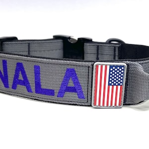 May include: A grey dog collar with a blue embroidered name "NALA" and a small American flag patch.
