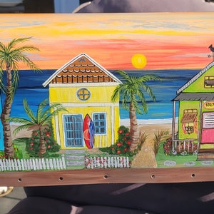 May include: Hand-painted mailbox with a beach scene featuring three colorful houses, palm trees, and a sunset. The houses have numbers 1233, 1237, and 1235.