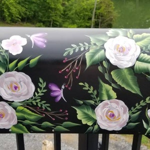 May include: Black mailbox with a hand-painted design of white roses, green leaves, and purple butterflies.